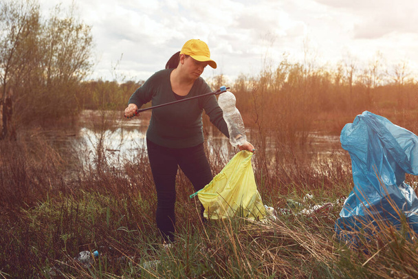 Ehrenamtliche und Umweltaktivisten säubern mit Müll gefülltes Seeufer. - Foto, Bild