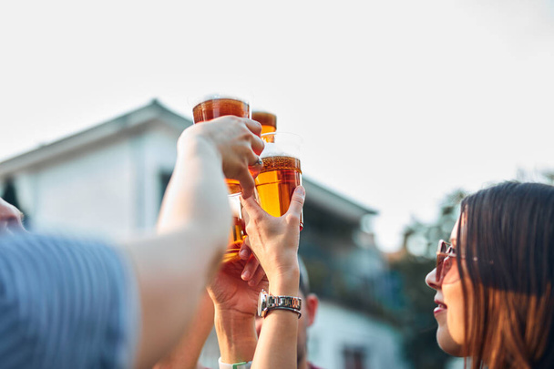 Baráti társaság, akik hideg sört isznak egy kerti partin.. - Fotó, kép