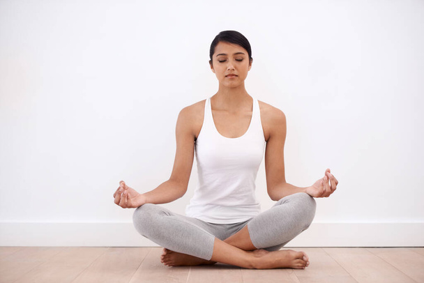 Vrouw, meditatie en spiritueel in een huis met lotus poseren en zitten voor evenwicht en mindfulness. Ochtend, wellness en zen in huis op de vloer om te ontspannen voor kalme ademhaling en innerlijke rust. - Foto, afbeelding