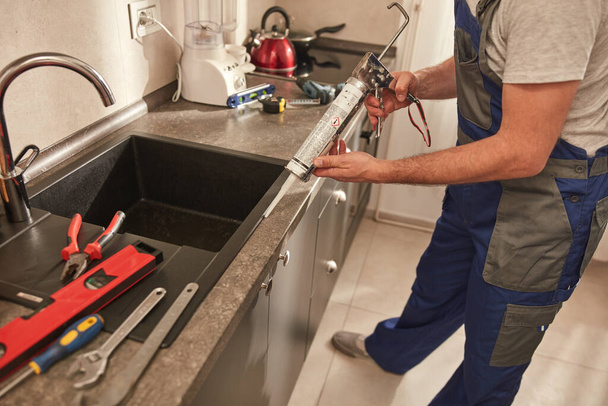 Handwerker repariert Küchenschränke in der Wohnung. - Foto, Bild