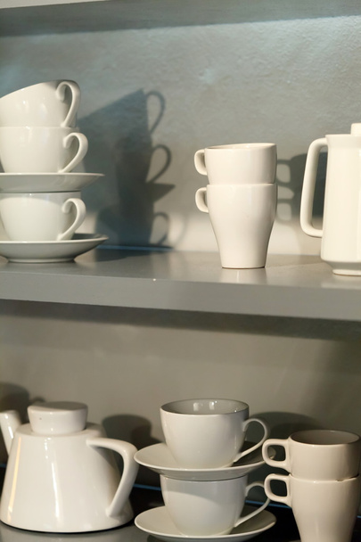 White cups on the shelf - Фото, изображение