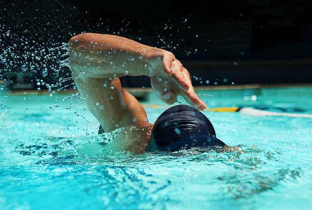 Pool, water splash and athlete swimming in sport for competition, race or training in cardio. Fitness, workout and person exercise for health, wellness or practice stroke or performance in gym. - Photo, Image