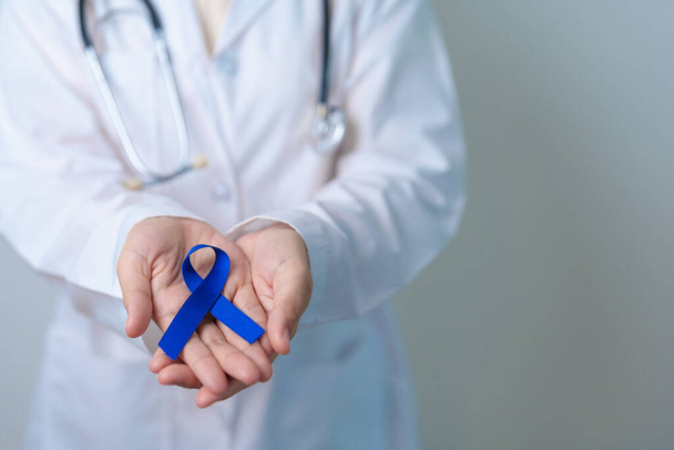Март Красочный месяц Рака награждения, врач с темно-синей лентой для поддержки людей, живущих и больных. Здравоохранение, надежда и Всемирный день борьбы с раком - Фото, изображение