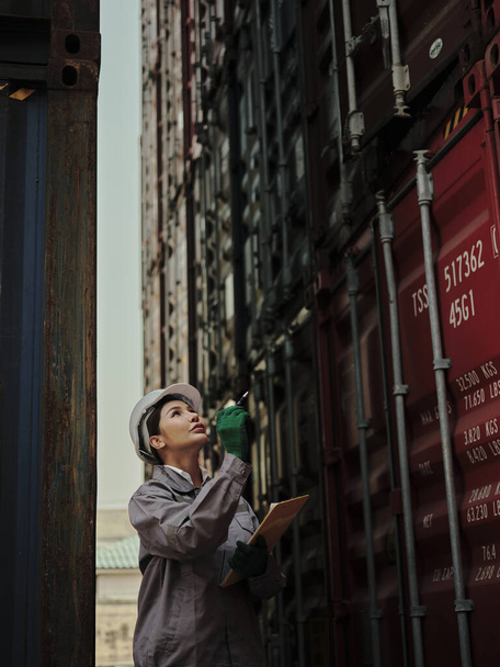 Retrato de uma trabalhadora segurando prancheta enquanto estava fora de um recipiente do armazém . - Foto, Imagem
