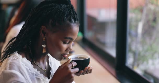 Καφετέρια, ευτυχισμένη και μαύρη γυναίκα από το παράθυρο με ποτό για χαλάρωση, ηρεμία και πρωινό στο καφέ. Εστιατόριο, Σαββατοκύριακο και πρόσωπο με κούπα, άρωμα και άρωμα για latte, καφεΐνη και καπουτσίνο. - Πλάνα, βίντεο