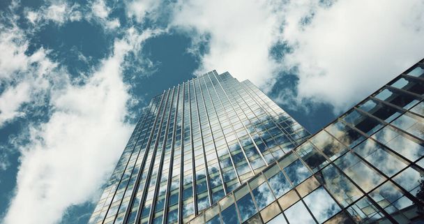 Low angle, skyscraper building and clouds with reflection, nature or urban infrastructure in city. Architecture, cityscape and skyline and metro with landscape, glass and sky background in timelapse. - Photo, Image