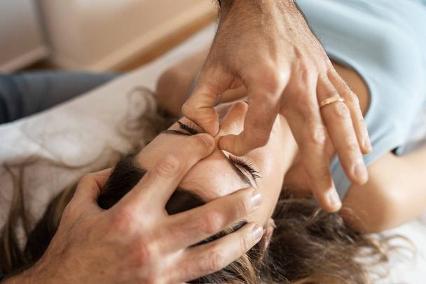 Therapist performing craniosacral treatment to alleviate stress and tension, enhancing patient's relaxation. - Photo, Image