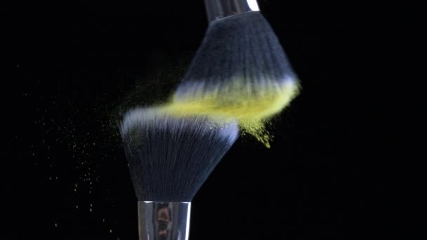Szczotki kosmetyczne zderzają się w ultra wolnym ruchu z żółtymi efektami cząsteczkowymi uchwyconymi w makrze z szybkim aparatem fotograficznym - Materiał filmowy, wideo