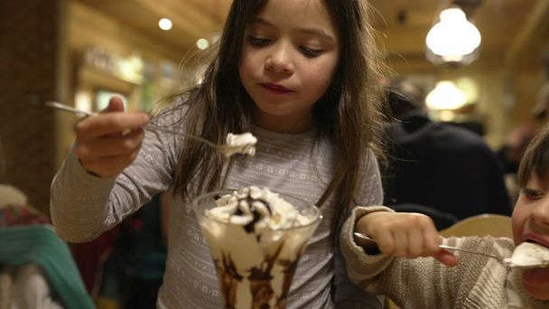 Malý bratr a sestra těší zmrzlina pohár se šlehačkou - Rodinný víkend výlet v restauraci Diner - Fotografie, Obrázek
