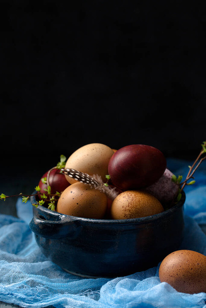 Nature morte avec des œufs dans un bol bleu sur un fond en bois, style rustique - Photo, image