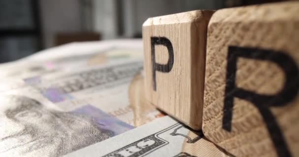 Winst op houten kubussen op geld dollar biljetten close-up 4k film slow motion. Succesvol bedrijfsconcept - Video