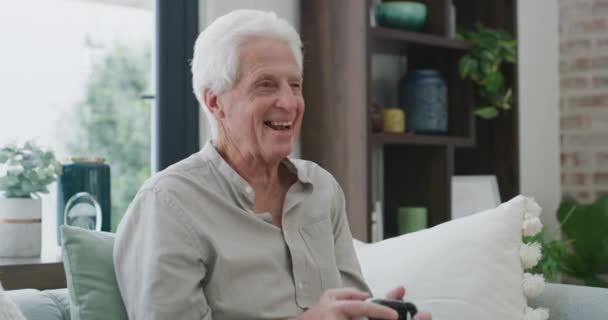 Старший чоловік, схвильований і контролер ігор, веселить і відзначає онлайн гру енергією, переможцем або геймером. Відставний, технології і кулак для перемоги, вітальня і насолоджуватися пенсійним часом. - Кадри, відео
