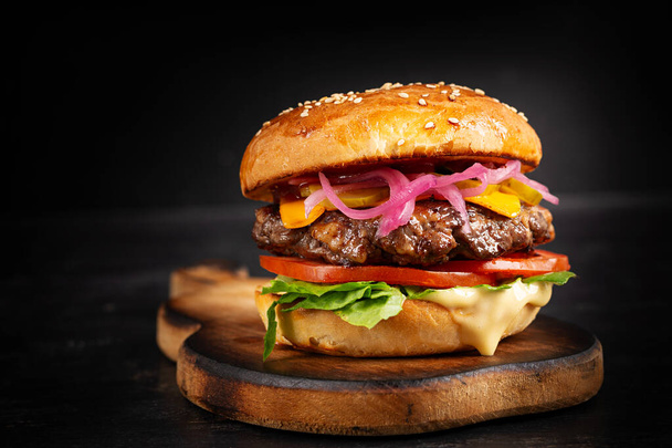 Beef hamburger. Sandwich with beef burger, tomatoes, cheese, pickled cucumber and lettuce. Cheeseburger. - Photo, Image
