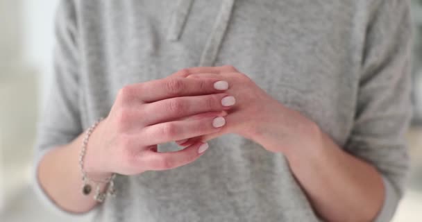 Lady removes wedding ring from finger with regret slow motion. Married woman takes off ring after getting divorce to demonstrate freedom. Divorce concept - Footage, Video