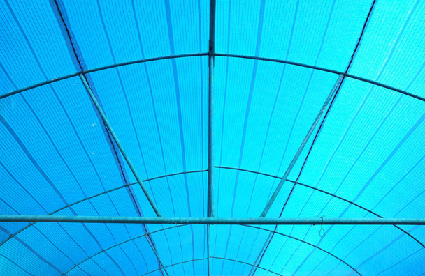 Modrá plastová plachta ve střídavých liniích. Je to kryt, který lze použít pro ochranu proti slunci, ochranu proti dešti na slunci, svěží barvy. používat jako zázemí v zemědělství a zakrytí zadní části vozu - Fotografie, Obrázek