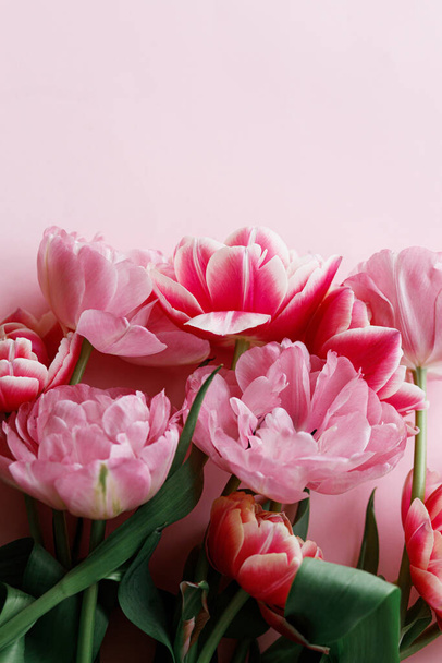 Красиві червоні тюльпани плоскі на рожевому тлі. Стильна квіткова облямівка з простором для тексту. Щасливий день Святого Валентина і щасливий день матері. Ніжний шаблон рожевих і червоних квітів - Фото, зображення