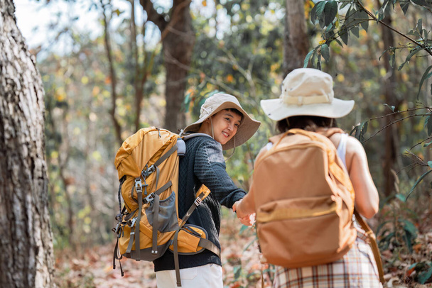 Szczęśliwa para lesbijek LGBT Wędrówki z plecakami w lesie Trail. LGBT Lesbijki Para Turyści z plecakami spacery w górach na wakacjach. - Zdjęcie, obraz