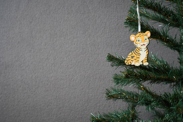 Zdjęcie choinki ozdobionej drewnianą zabawką noworoczną w postaci małego lwa do robienia pocztówek - Zdjęcie, obraz