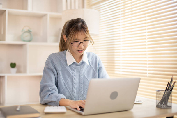 Женщина, печатающая перед ноутбуком, клавиатура для ноутбука, намерение работать в офисе. - Фото, изображение