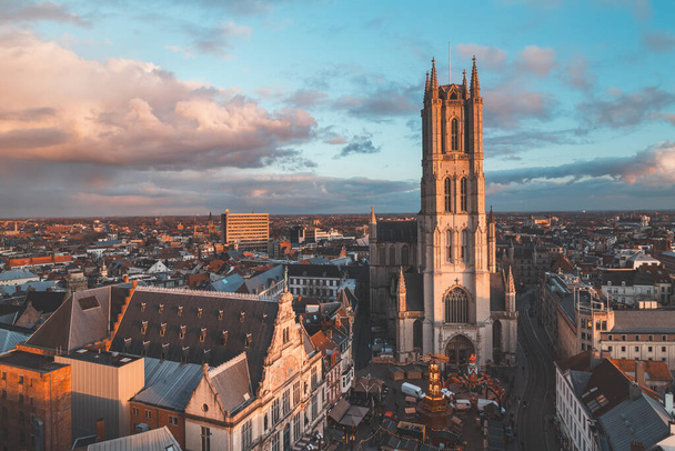 Вид на закат над Гентом с исторической башни в центре города. Романтические цвета в небе. Красный свет, освещающий Гент, Фландрия, Бельгия. - Фото, изображение