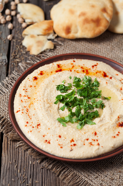 Hummus en tazón con pita tradicional árabe snack saludable de garbanzos, aceite de oliva y pimentón
 - Foto, imagen
