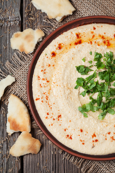 Hummus saludable vegano ensalada cremosa comida de proteína con aceite de oliva, pimentón y perejil
 - Foto, imagen