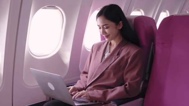 アジアのビジネスマンがラップトップに取り組んでおり,飛行中にタスクを積極的に記録し分析しています. 彼女は輸送中に生産性を最大化することに専念しています.  - 映像、動画
