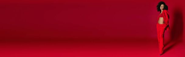 приваблива сексуальна афроамериканка в яскравому вбранні, дивлячись на камеру на червоному тлі, банер - Фото, зображення