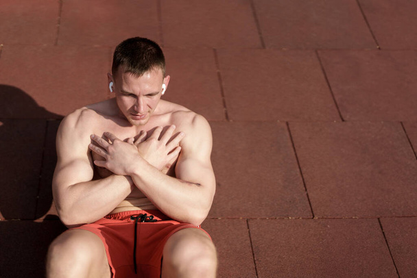 Hombre enfocado comprometido en un entrenamiento abdominal en un entorno de parque sereno, haciendo hincapié en la fuerza del núcleo - Foto, imagen