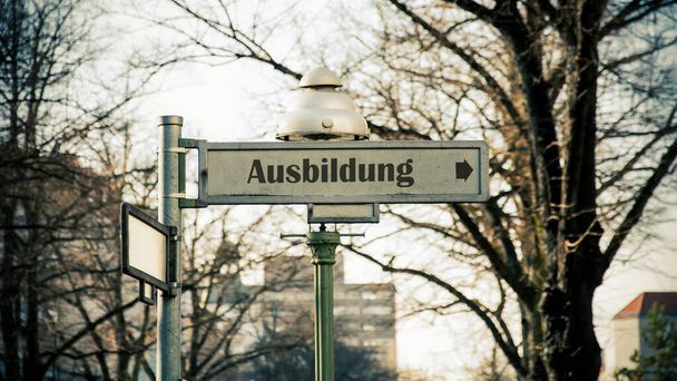 A kép egy táblát és egy jelet mutat a német oktatás irányában.. - Fotó, kép