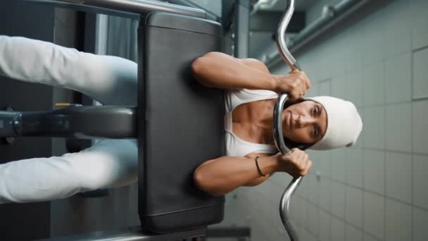 Çekici kadın spor salonunda halterli bisepslerle ağırlık çalışması yapıyor. - Video, Çekim