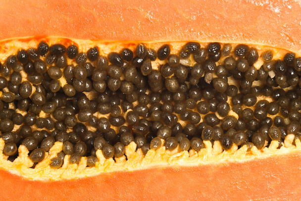 Κοντινές λεπτομέρειες υφή σπόροι του φρέσκου βιολογικού παπάγια νόστιμα φρούτα που απομονώνονται σε λευκό φόντο μονοπάτι απόκομμα - Φωτογραφία, εικόνα