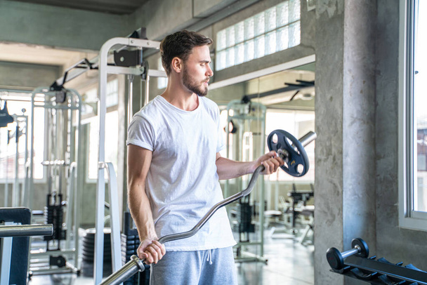 Sport man lifting barbell peso ejercicio indoor gimnasio estilo de vida saludable - Foto, Imagen