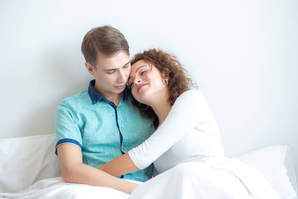 Любов пара лежить на білому ліжку вранці щаслива і турбує разом розслаблення любові
 - Фото, зображення