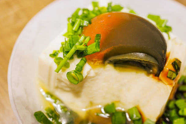新鮮な緑のタマネギをまぶした絶妙な世紀の卵豆腐のプレート - 写真・画像