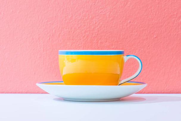 Keltainen kahvikuppi oranssilla seinällä, Thaimaa. - Valokuva, kuva