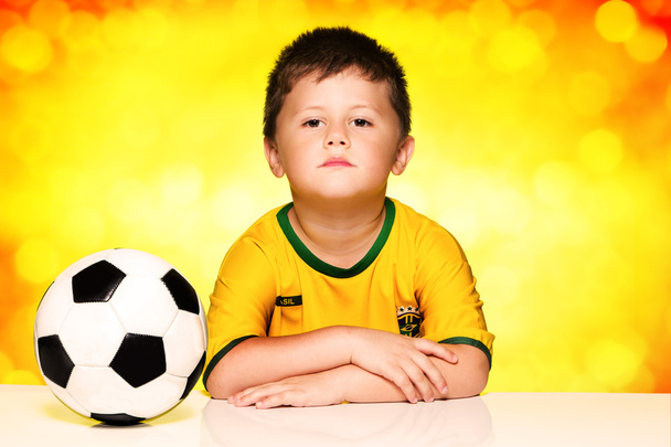 Хлопчик у бразильській національній футбольній сорочці та м'ячі
 - Фото, зображення