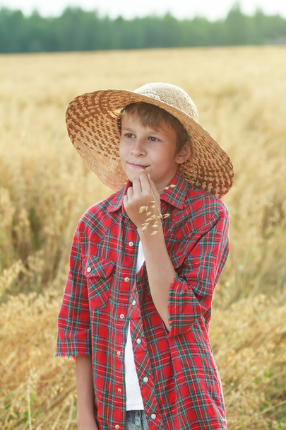 Portrét dospívající farmářský chlapec v širokou krempou klobouku a ovesného uši sláma - Fotografie, Obrázek