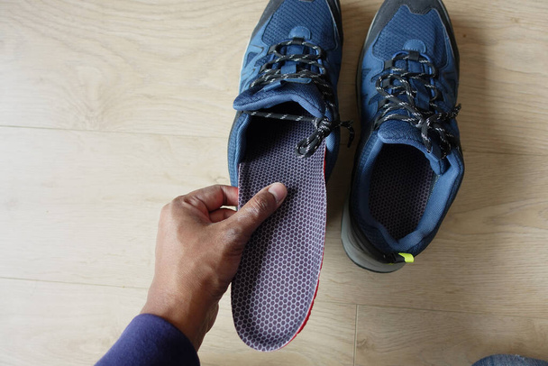 Männer legen orthopädische Einlegesohlen in Schuhe . - Foto, Bild