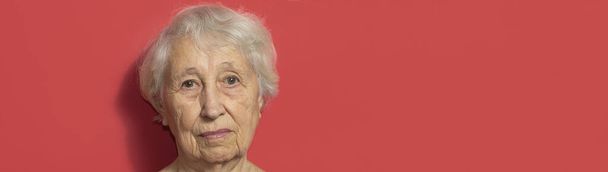 Close up portrait of senior woman against red background - flyer - Photo, Image