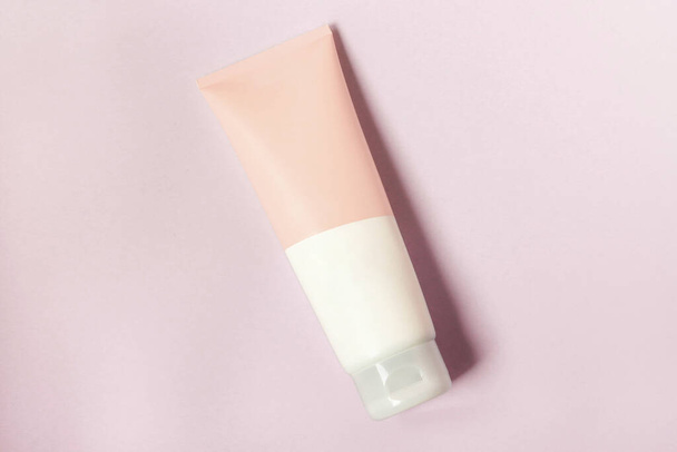A clean label facial or body cream tube is isolated on a pink background. Beauty product mockup. Wellness packaging. Branding spa. Cream bottle, lotion, mousse, cleanser, shampoo for skincare routine. Copy space. - Photo, Image