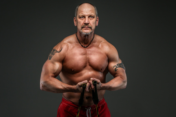 Hombre musculoso de mediana edad mostrando sus músculos
 - Foto, imagen