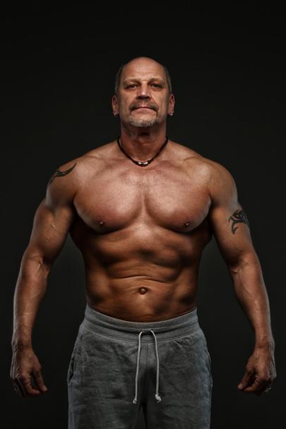 Mięśni średnim wieku człowiek pokazano jego muscules - Zdjęcie, obraz