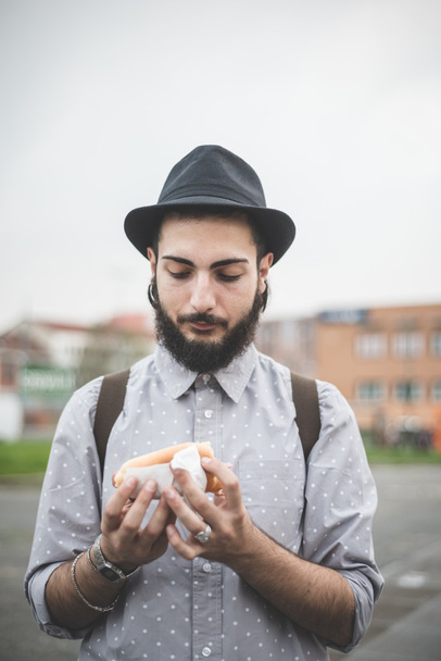 Hombre moderno comiendo hot dog
 - Foto, Imagen