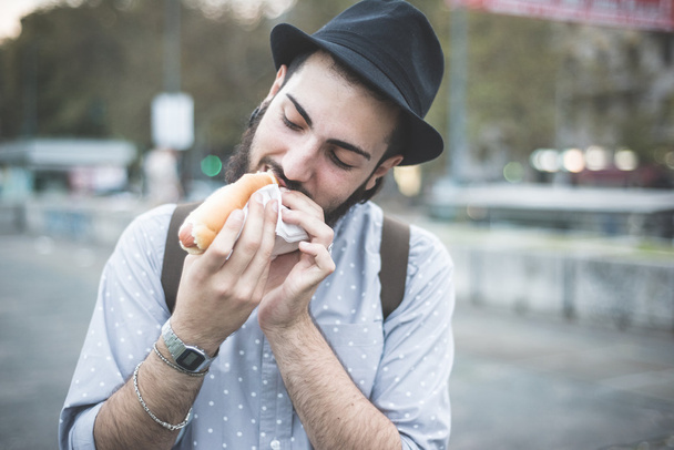 moderner Mann isst Hot Dog - Foto, Bild