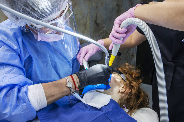 стоматолог і асистент під час стоматологічного лікування пацієнта - Фото, зображення