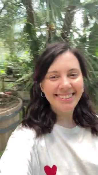 mujer tomando selfie hablando en cámara al aire libre soleado día de verano - Imágenes, Vídeo