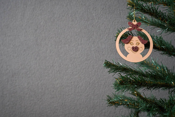 Zdjęcie choinki ozdobionej drewnianą zabawką noworoczną w postaci świni do robienia pocztówek - Zdjęcie, obraz