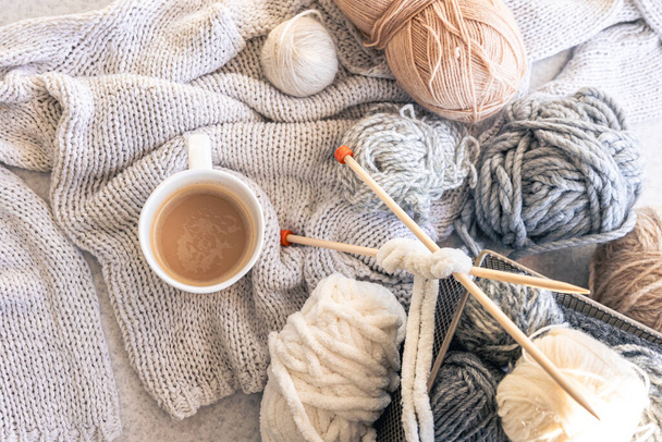 Filati, elementi lavorati a maglia e una tazza di caffè, vista dall'alto. Concetto di maglieria, hobby invernale. - Foto, immagini