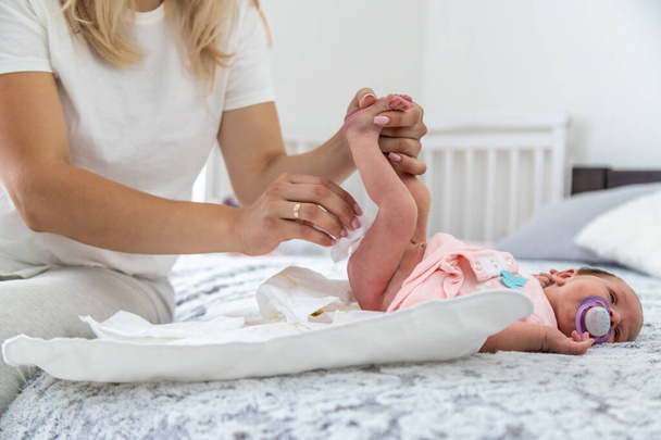 A mother changes her child's diaper, close-up - Foto, Imagem